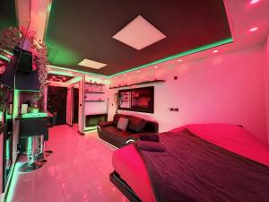 a pink bedroom with a bed and a couch at C12 Deluxe in Cap d'Agde