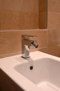 lavabo con grifo en el baño en Lucalì Mountain Room, en Ponte di Legno