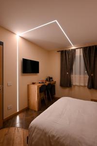 1 dormitorio con 1 cama y escritorio con TV en Lucalì Mountain Room, en Ponte di Legno
