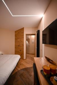 1 dormitorio con cama, mesa y TV en Lucalì Mountain Room, en Ponte di Legno