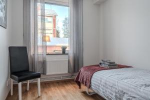 1 dormitorio con 1 cama y 1 silla junto a una ventana en Piteå City Charm - Stay & Work en Piteå