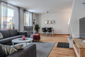 a living room with a couch and a table at Guestly Homes - 3BR City Charm in Piteå