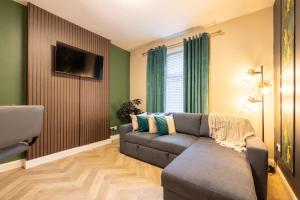 a living room with a couch and a television at Violet Suite Apartments in Derry Londonderry