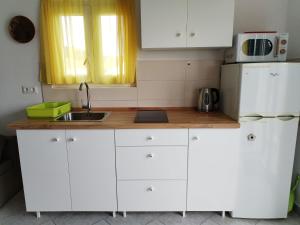 a white kitchen with a sink and a refrigerator at Apartment Branko in Sutomišćica