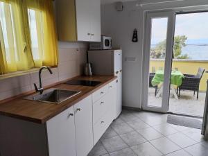 a kitchen with a sink and a view of the ocean at Apartment Branko in Sutomišćica