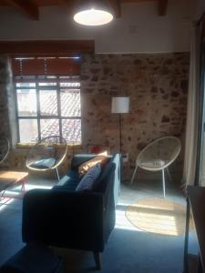 een woonkamer met een blauwe bank en stoelen bij Casa Buscareta in Montán