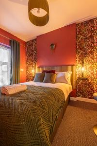 Violet Suite Apartments في ديري لندنديري: غرفة نوم بجدران حمراء وسرير كبير