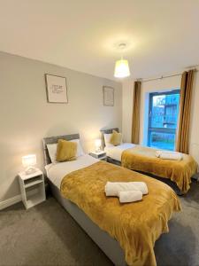 a hotel room with two beds and a window at Contractor Accommodation Specialist, 3 bedroom house with FREE Parking, Wifi & Netflix! in Milton Keynes