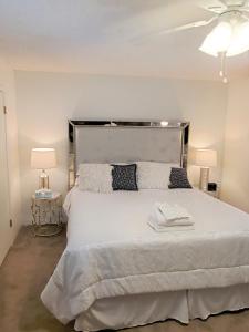 a bedroom with a large white bed with two lamps at Jacob's Well in Redding