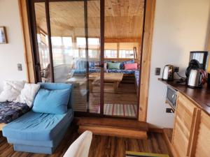 a living room with a blue couch in a tiny house at Puerto Austral in Puerto Varas