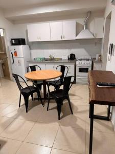 una cocina con mesa de madera y sillas. en Los Halcones, en Mendoza