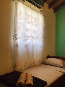 a bedroom with a window with a white curtain at Grecovich House in Encarnación