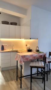 a kitchen with white cabinets and a table with chairs at Apartament a Sant Celoni, Montseny in Sant Celoni