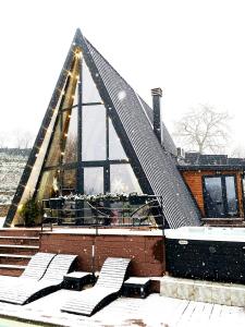 a building with a triangular roof in the snow at Forrest Relax & Spa in Rakovac