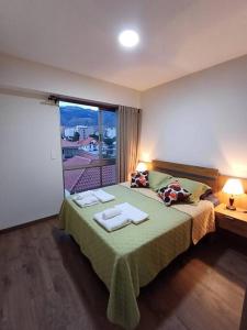 1 dormitorio con 1 cama con 2 toallas en Un lugar para ti en Cochabamba. en Cochabamba