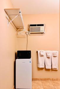 um quarto com um frigorífico e ar condicionado em Fundy Line Motel em Miramichi