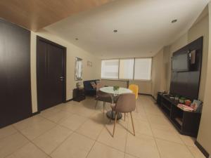 una pequeña sala de estar con mesa y TV en #3 Luxury Suite en Puerto Santa Ana, en Guayaquil