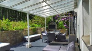 eine Terrasse mit einem Tisch, Stühlen und einem Kamin in der Unterkunft Ferienhaus mit Sauna, Whirlpool und Garten in Wuppertal