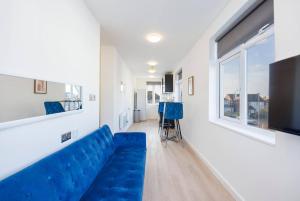 a living room with a blue couch and a window at North West London Studio Apartment By AV Stays Short Lets London in London