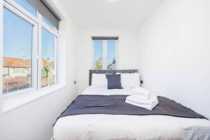 biała sypialnia z łóżkiem i oknem w obiekcie North West London Studio Apartment By AV Stays Short Lets London w Londynie