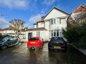 two cars parked in a parking lot in front of a house at North West London Studio Apartment By AV Stays Short Lets London in London
