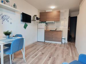 托雷莫利諾斯的住宿－Estudio Copenhague，厨房配有白色冰箱、桌子和椅子