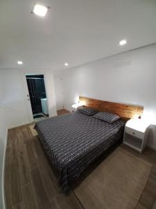 Un dormitorio con una cama grande con cabecero de madera. en Terraços da Serra, en Painho