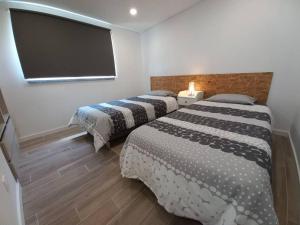 Habitación con 2 camas y TV de pantalla plana. en Terraços da Serra, en Painho