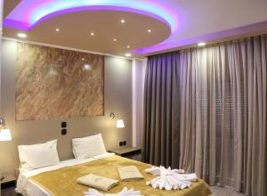 a bedroom with a large bed with a purple ceiling at Hotel Dionysos Polichrono in Polychrono