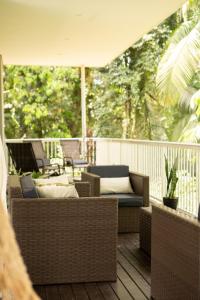 a porch with wicker furniture and an umbrella at Holzhaus Blumenau in Blumenau