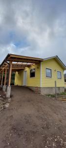 uma casa amarela com um telhado de gambrel em cabaña los teros em Coihaique