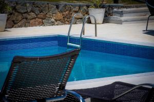 una silla sentada junto a una piscina en Pousada Gammel Dansk by Latitud Hoteles, en Búzios