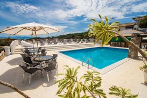 - Piscina con sillas, mesa y sombrilla en Pousada Gammel Dansk by Latitud Hoteles, en Búzios