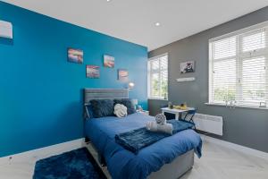 a blue bedroom with a bed and a blue wall at West Five, Double Bedroom Suite with Private Bathroom in London