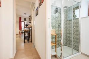 a glass shower in a hallway with a table at Peri Peri House - Palermo Centro in Palermo