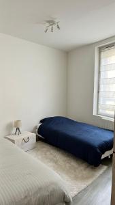 una camera bianca con due letti e una finestra di Ibiscus-Immoploc a Dieppe