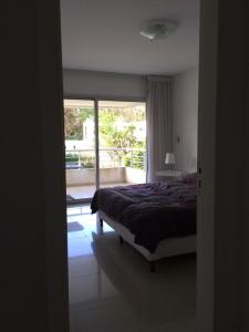a bedroom with a bed and a large window at Altos del Golf - Fito in Punta del Este