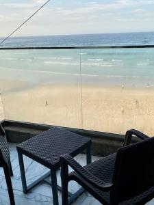 un balcon avec une table et des chaises et une plage dans l'établissement L’écho des vagues, à Dakar