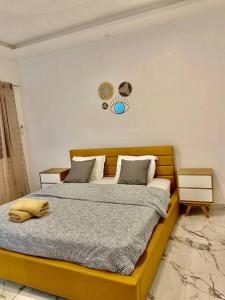 - une chambre avec un grand lit à cadre jaune dans l'établissement L’écho des vagues, à Dakar