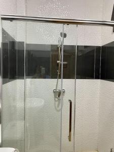 une douche avec une porte vitrée dans une salle de bain dans l'établissement L’écho des vagues, à Dakar