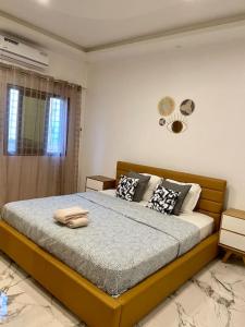 une chambre avec un grand lit avec des oreillers dessus dans l'établissement L’écho des vagues, à Dakar 45 autres photos