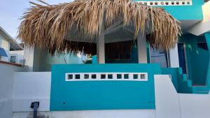 a blue house with a thatched roof at Blue Lights Curaçao in Willemstad