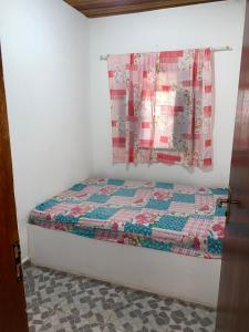 een slaapkamer met een bed met een quilt bij Sitio 2k Mairinque in Mairinque