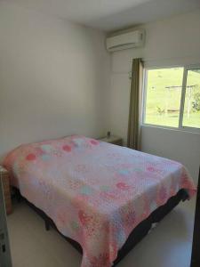 um quarto com uma cama com um cobertor rosa em Sítio dos Gaitas Vila Hoffmann em São Pedro de Alcântara