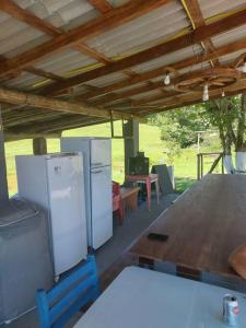 uma cozinha com 2 frigoríficos e uma mesa de madeira em Sítio dos Gaitas Vila Hoffmann em São Pedro de Alcântara