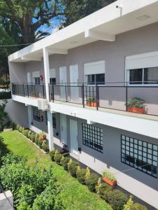 un edificio de apartamentos con balcones y plantas en MAKTUB DEPARTAMENTOS Y HABITACIONES en Alta Gracia