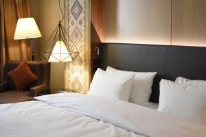 a bedroom with a bed and a chair and a lamp at Radisson BLU Hotel Yerevan in Yerevan