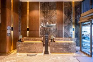 a lobby of a hotel with a restaurant sign on the wall at Radisson Residences Vadistanbul in Istanbul