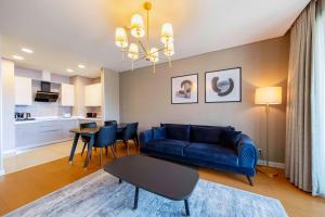 a living room with a blue couch and a table at Radisson Residences Vadistanbul in Istanbul