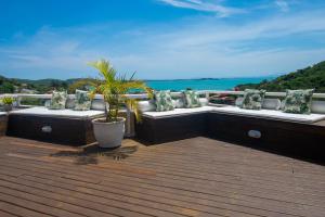 Un balcón con sofás y vistas al océano. en Pousada e Spa Villa Mercedes by Latitud Hoteles, en Búzios